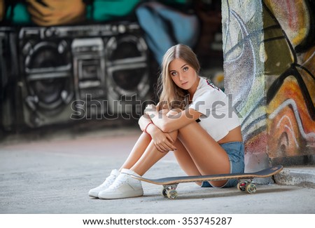 Portrait of young girl with skate posing at city streets