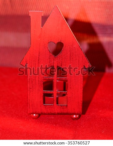 Conceptual red wooden house with window, chimney and heart on the roof
