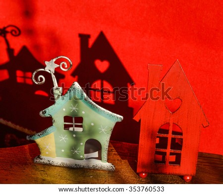 Two Christmas decorative houses with shadows on red background