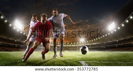 Soccer players in action on the sunset stadium background panorama