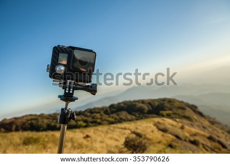 Action camera with selfie pole on the peak of mountain Royalty-Free Stock Photo #353790626