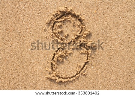Number 8 handwritten on sand.