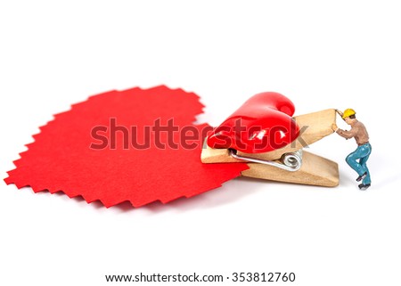 selective focus of miniature workers holding red heart shape wood  clip with paper for your text on white background , abstract background to valentine concept.