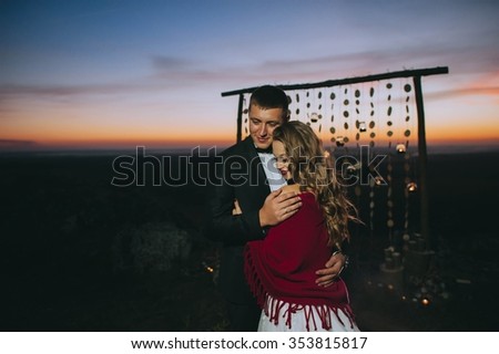 Silhouette of a young bride and groom on sunset background