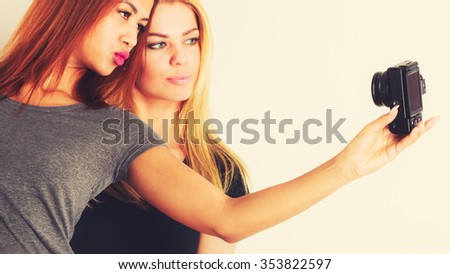 Technology internet and happiness concept. Young women blonde and mixed race taking self picture selfie with smartphone camera 