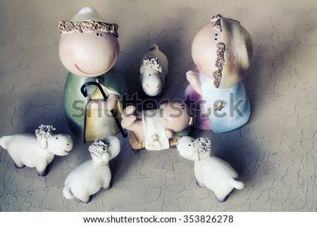 Closeup view of decorative celbrating Christmas and Jesus birth figurines of holy vergin Mary Josepd newborn child with few white sheeps standing on light leather background, horizontal picture