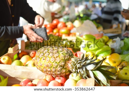 Picture of money exchanging hands at a fruit market stall