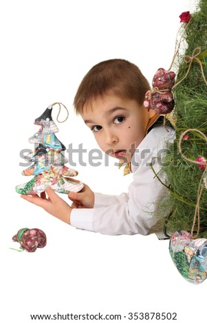 a baby boy holds in a hand toys for a fir-tree on a white background advertising the winter New Year. toys vintage, warm winter