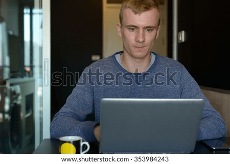 Man sitting and using laptop computer in his home
