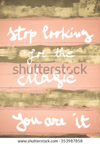 Concept image of Stop Looking For the Magic, you are it motivational quote hand written on vintage painted wooden wall