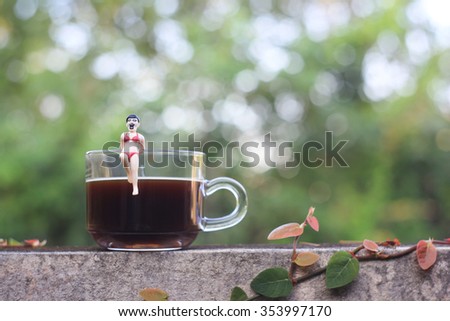 Japanese gashapon toy playing with a glass of coffee 
