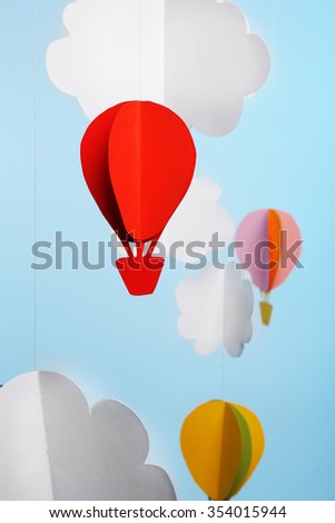 Paper clouds and airship on blue background