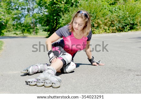 young woman dressed in pink fell on skates