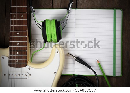 Electric guitar with headphones  on wooden background