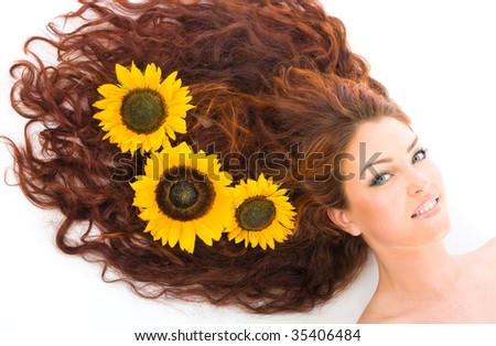 Close-up beautiful young red haired model girl with sunflowers in studio shot isolated on white background