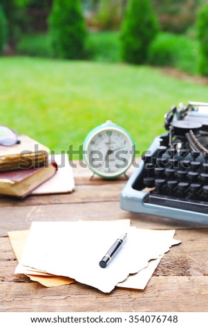 Vintage black typewriter on wooden table, outdoors