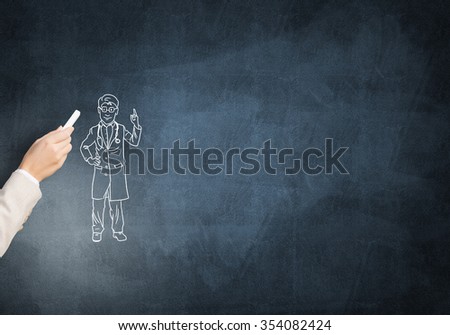 Female hand drawing with chalk doctor man on blackboard