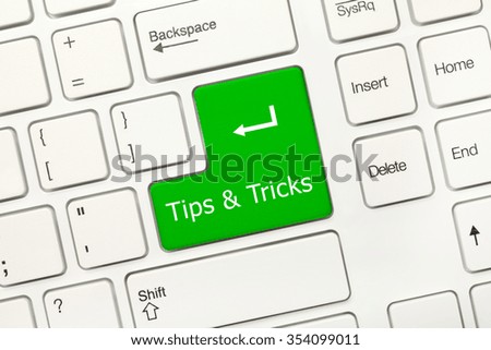 Close-up view on white conceptual keyboard - Tips and Tricks (green key)