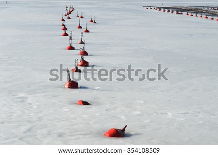 Bright red buoys rhythm on fresh ice background