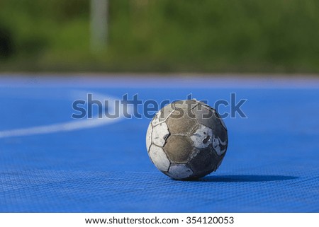 Old soccer ball on blue football field, Natural background 