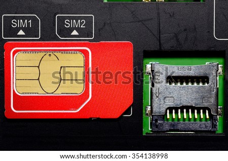 Red SIM card on slots in mobile phone. Close up view of the inside. Two seats for the card.