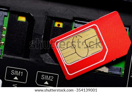Red SIM card on slots in mobile phone. Close up view of the inside. Two seats for the card.