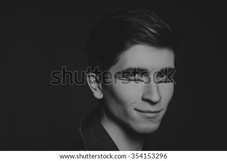 Professional game young actor. Black and white photo on a dark background. Professional makeup and theatrical image. Photo for cultural and fashion magazines and websites.
