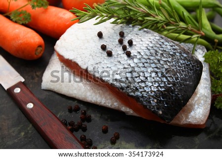 raw salmon fillets with other ingredients on marble stone chopping board