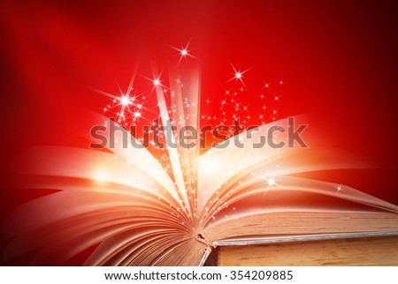 Opened magic book on abstract red gold background 