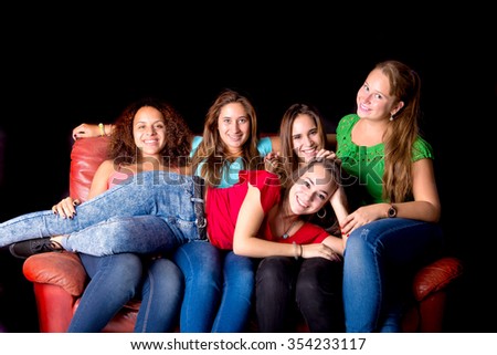 teenage girls at the movies isolated in dark background