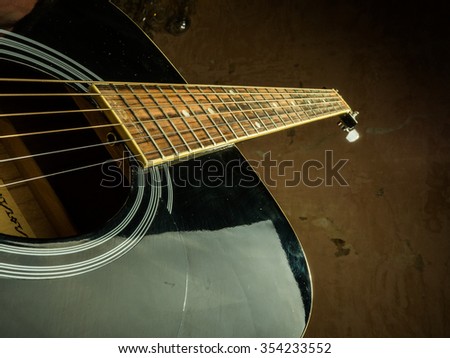Closeup photo of an acoustic guitar played by a man. Only hands visible. Unrecognizible guitar player.