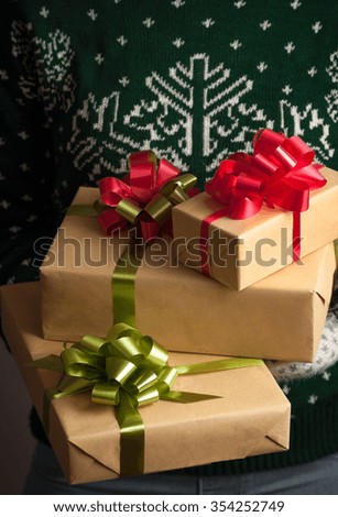 Christmas gifts. Knitted mittens. Woman holding a gifs. Knitted dress. Box with gifts. Present. Shallow depth of field. Valentine Day.