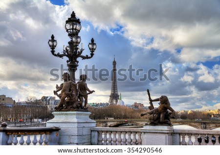 Beautiful view of a lantern on the Pont Alexandre III in Paris, with the Eiffel tower in the background, on a cloudy winter day 