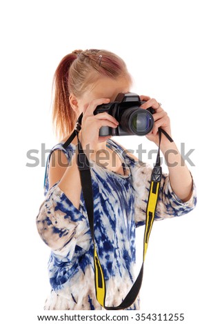 A young girl in blue blouse standing in profile and taking
pictures, isolated for white background.
