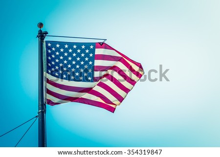 American flag on blue sky ( Filtered image processed vintage effect. )