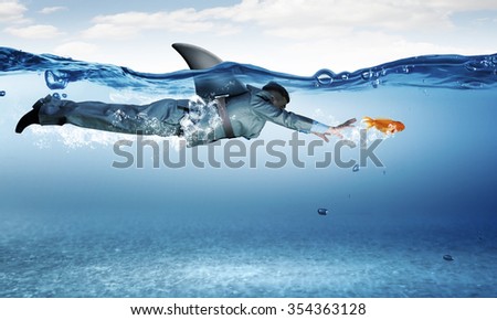 Young businessman with shark flipper swiming under water Royalty-Free Stock Photo #354363128