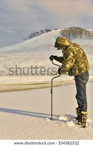 Photo of a fisherman, drilling ice. So fishing begins...