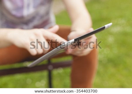 Young man read news and communicate on social networks with tablet computer in park