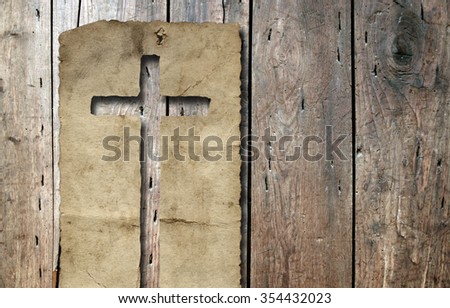 Concept or conceptual Christian cross cut in an old grungy or vintage paper, over a wood texture background for religion, retro, aged, grunge, faith, holiday, God, religious, Jesus or belief designs