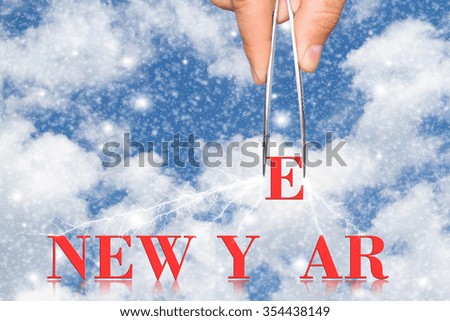 Word new year and hand with tweezers on  background
