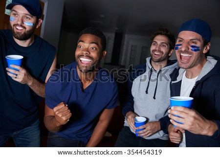 Group Of Male Sports Fans Watching Game On Television