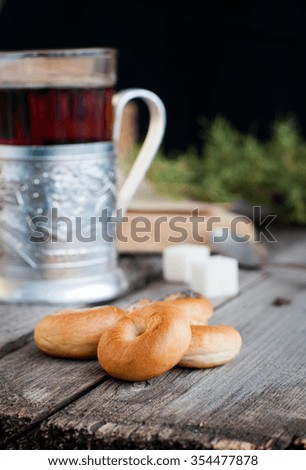 Homemade bagels and black tea in a glass with a metal Coasters, selective focus