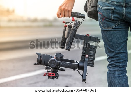 Videographer with gimbal video camera dslr, Professional video equipment, Videographer in event film production shoot video. Royalty-Free Stock Photo #354487061