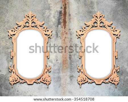 Close-up of two baroque picture frames on stained concrete wall background
