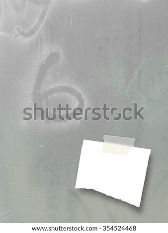 Close-up of one piece of paper with tape on metal sheet background