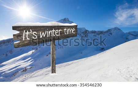 Wooden sign It's winter time. Ski-track with Caucasus mountains on background. Mountains landscape panorama. No people. Winter, snow and sunshine.