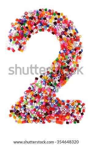 Figure two "2"  composed using plastic particles of different colors isolated on white background.