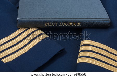 Pilot logbook with Captain 4 gold stripes on sleeves.