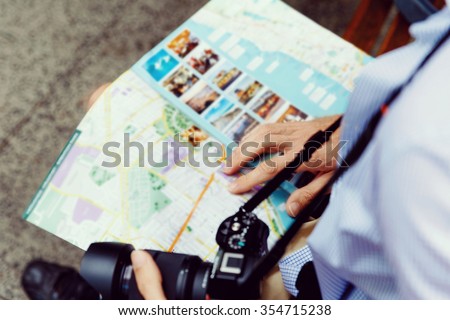 Happy male tourist in city with camera and map Royalty-Free Stock Photo #354715238