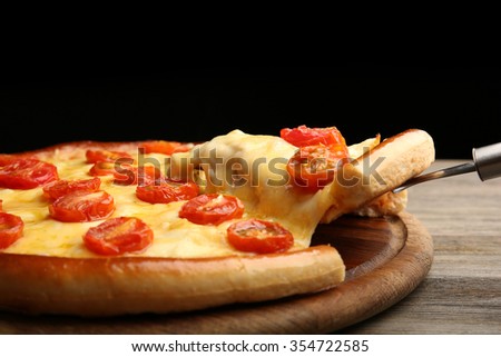 Pizza Margherita and removed slice on dark background